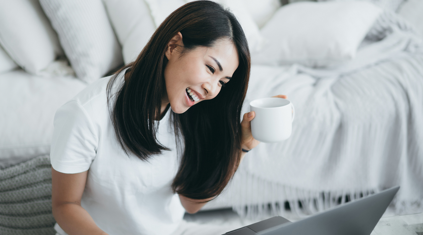 Happy woman with coffee and computer