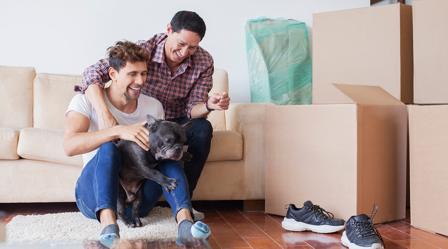 Happy couple with dog and moving boxes